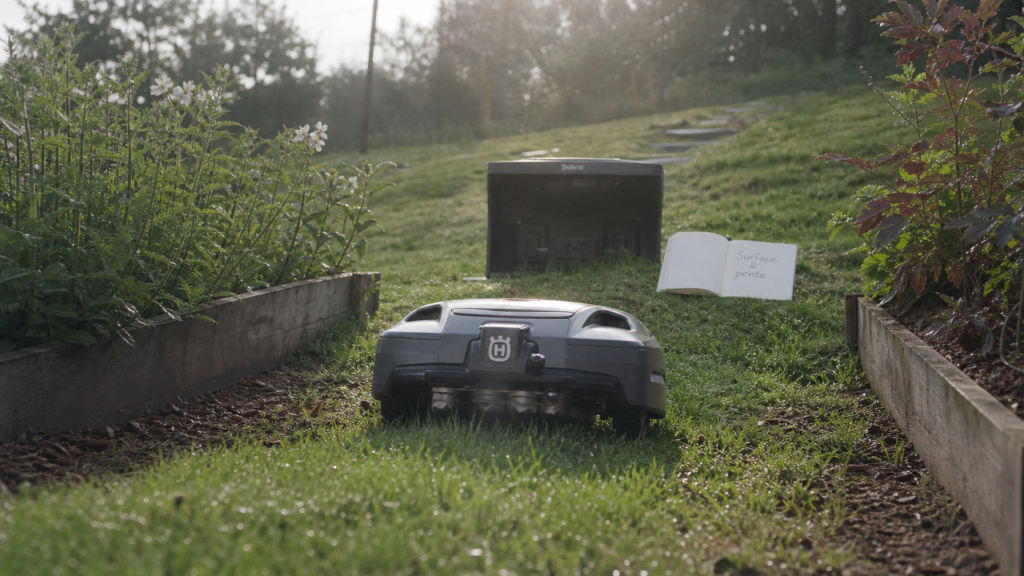 Meilleur robot tondeuse 2025 : robot sur pente avec GPS RTK, surface et brins d’herbe près de la bordure